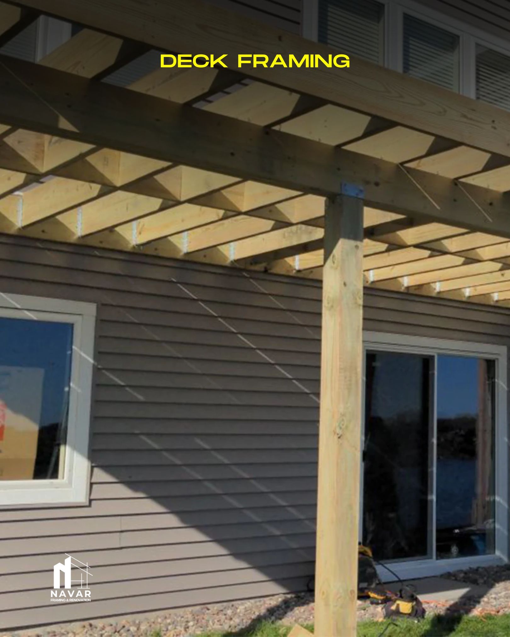 Crew building a wooden deck frame with pressure-treated lumber and joist hangers.